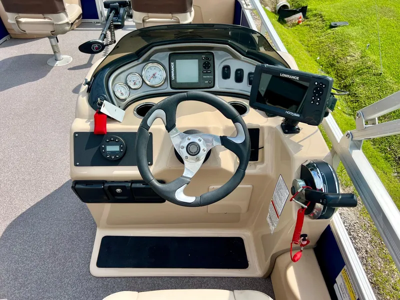 Slide: The Image of 2017 Sun Tracker Fishin' Barge 22 DLX dashboard with steering wheel and navigation equipment. - 12