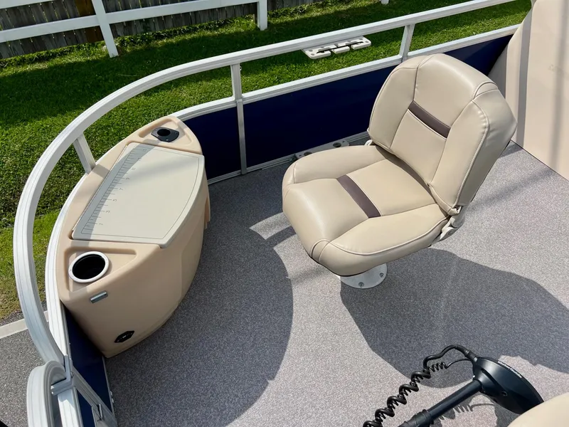 Slide: The Image of 2017 Sun Tracker Fishin' Barge 22 DLX interior with beige seating and control panel. - 16
