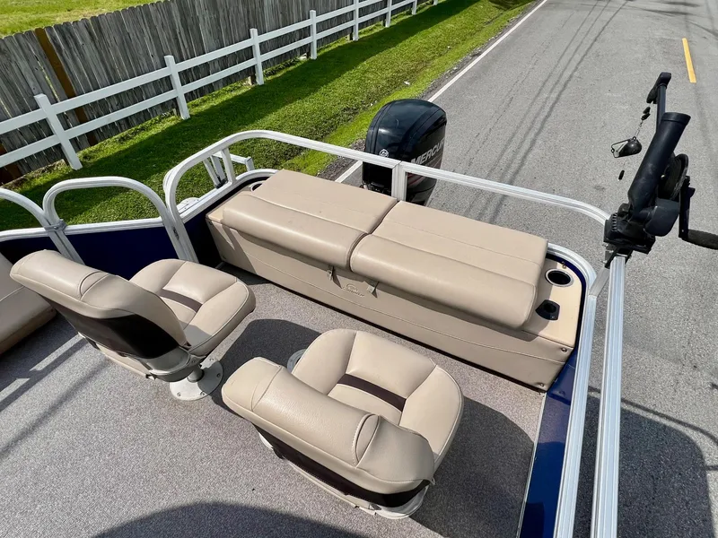 Slide: The Image of 2017 Sun Tracker Fishin' Barge 22 DLX with beige seating and railing on a road. - 7