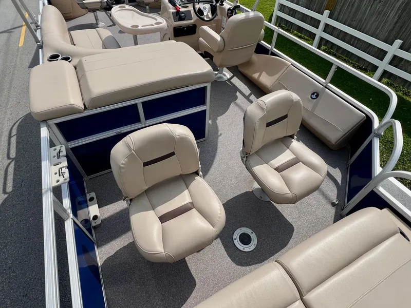 Slide: The Image of 2017 Sun Tracker Fishin' Barge 22 DLX interior with beige seating and steering console. - 8