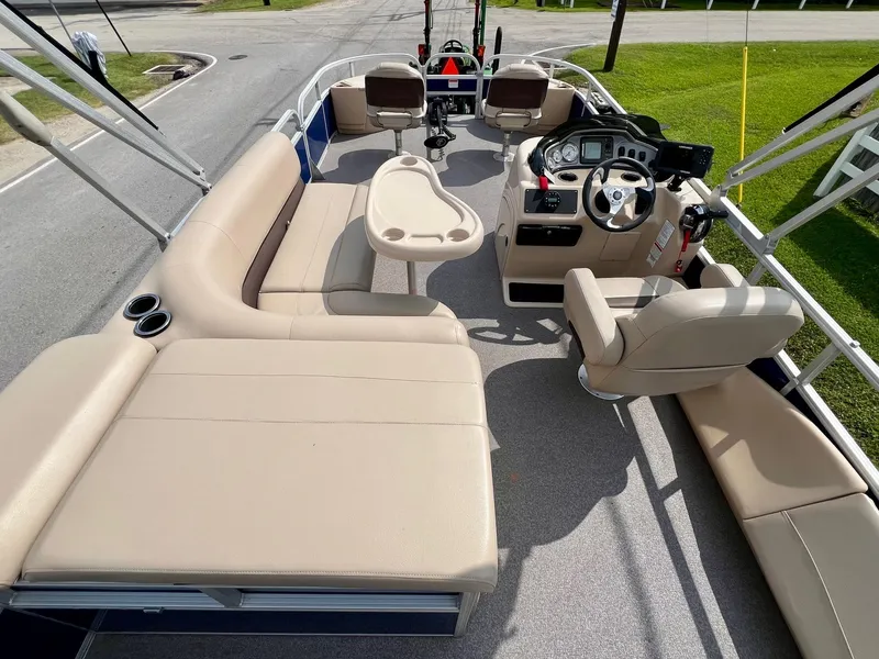 Slide: The Image of 2017 Sun Tracker Fishin' Barge 22 DLX interior with beige seating and steering console. - 9