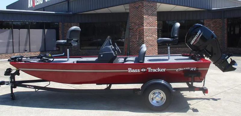 The Image of 2025 Tracker BASS TRACKER® Classic XL boat on trailer, parked outside a brick building. - 0