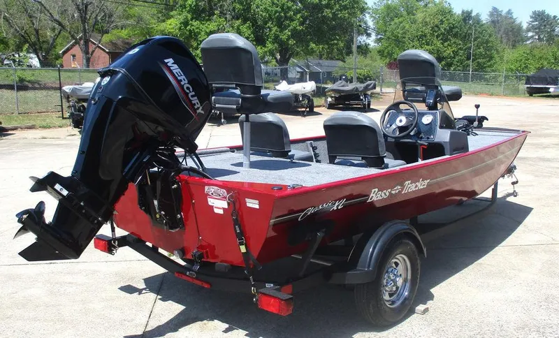 Slide: The Image of 2025 Tracker BASS TRACKER® Classic XL boat with Mercury engine, parked outdoors. - 2