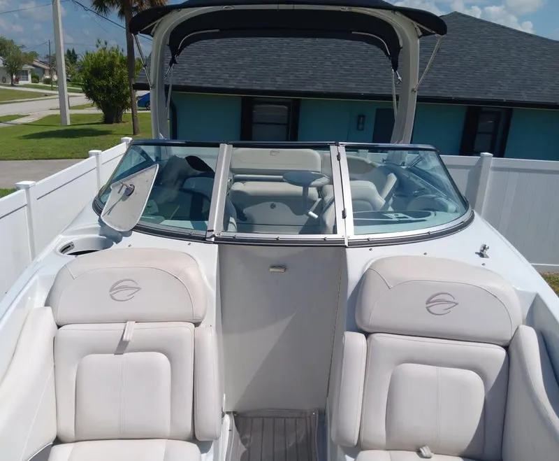 Slide: The Image of 2017 Crownline 275 SS boat with white interior and windshield, parked outdoors. - 2