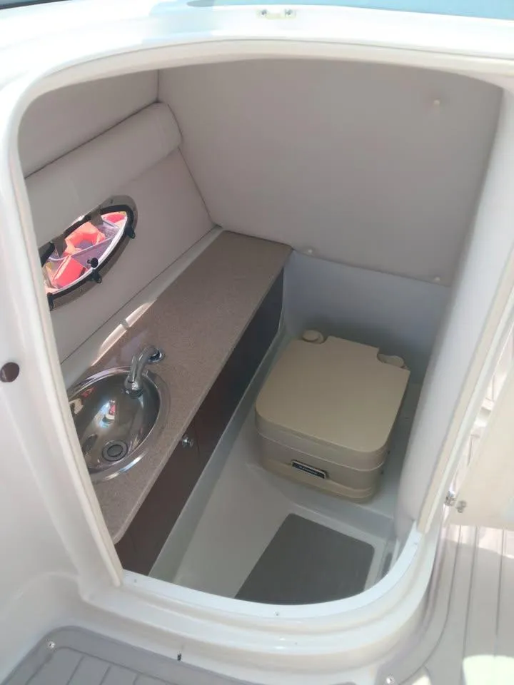 Slide: The Image of 2017 Crownline 275 SS boat interior with sink and portable toilet. - 8