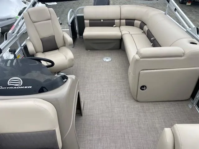 Slide: The Image of 2022 Sun Tracker Party Barge 20 DLX interior with beige seating and steering console. - 10