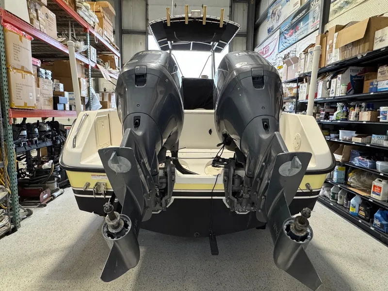 Slide: The Image of 2004 Pursuit 2470 CC boat with dual outboard motors in a storage facility. - 10