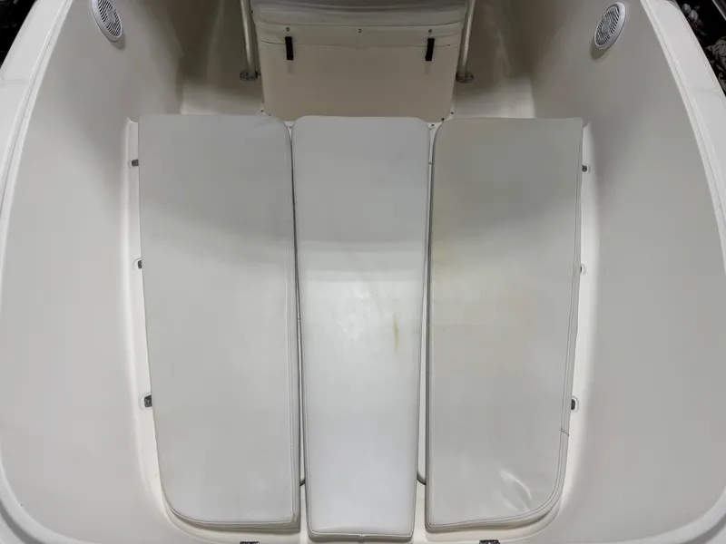 Slide: The Image of 2004 Pursuit 2470 CC boat interior with cushioned seating and storage compartments. - 11
