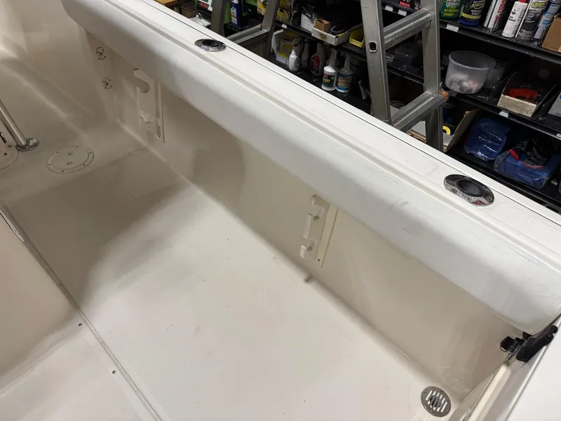 Slide: The Image of 2004 Pursuit 2470 CC boat interior, showing clean white deck and storage compartments. - 17