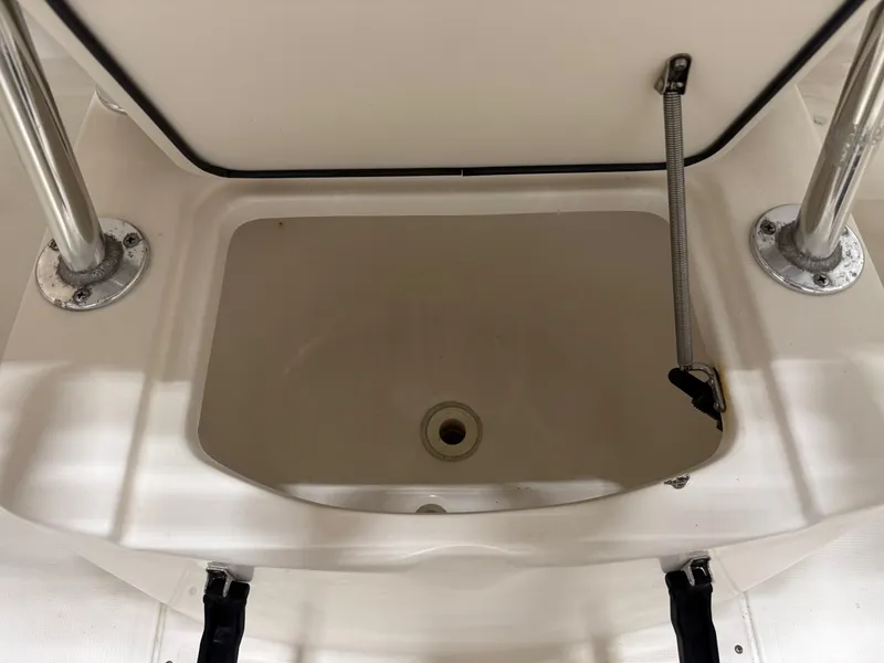 Slide: The Image of Livewell compartment on a 2004 Pursuit 2470 CC boat, featuring stainless steel supports. - 19