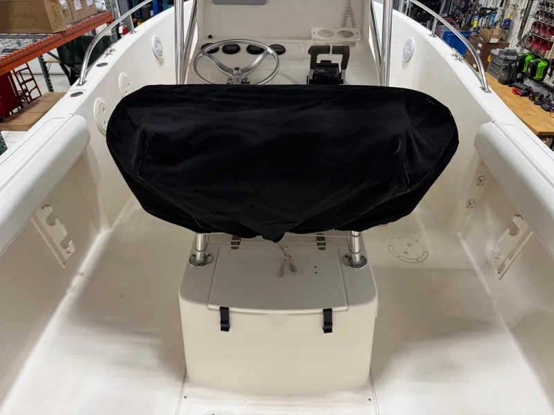 Slide: The Image of 2004 Pursuit 2470 CC boat interior with covered console and steering wheel. - 20