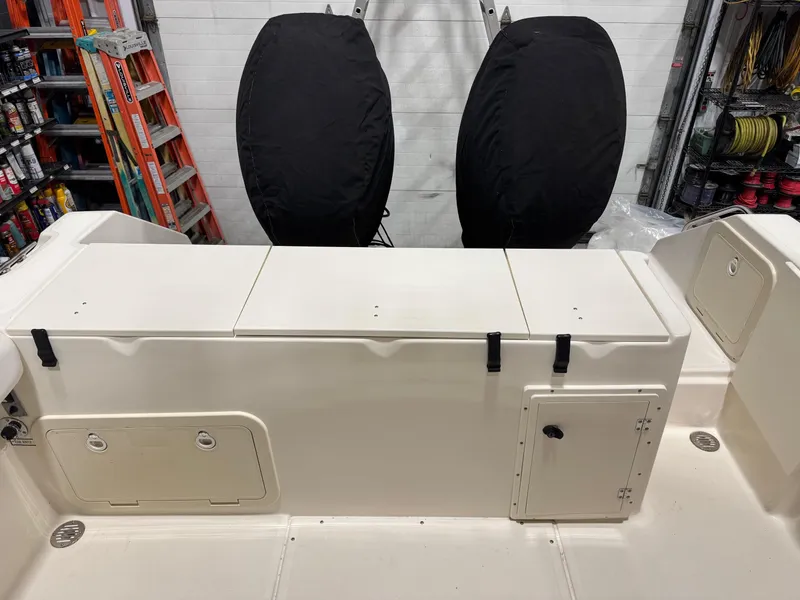 Slide: The Image of 2004 Pursuit 2470 CC boat interior with storage compartments and covered engines. - 23