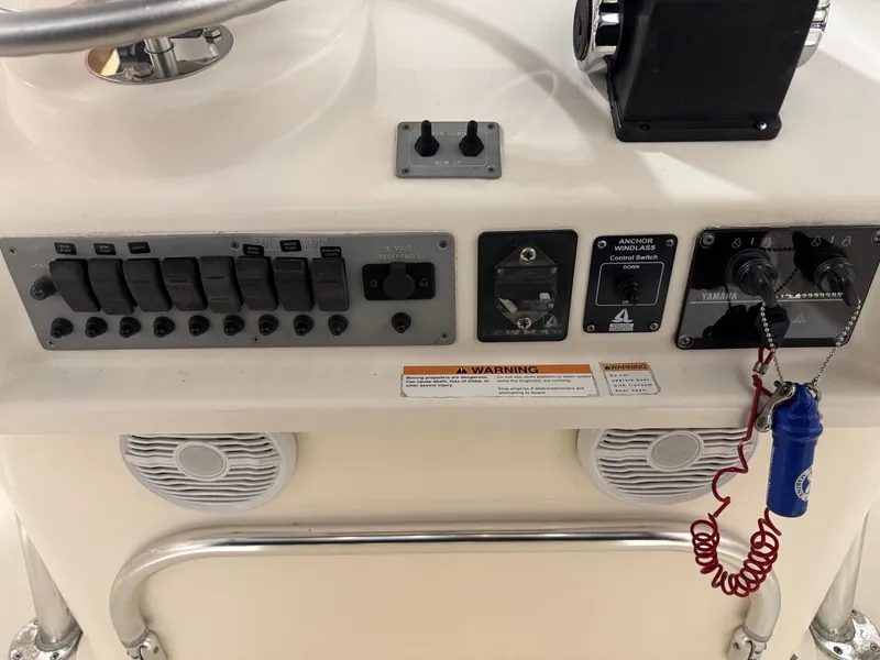 Slide: The Image of Control panel of a 2004 Pursuit 2470 CC boat with switches and speakers. - 24