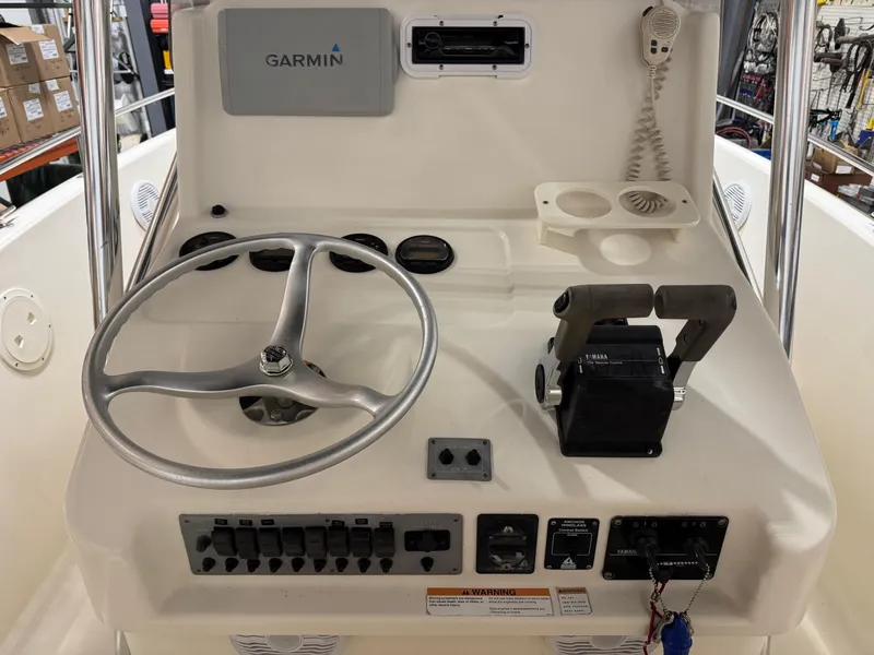 Slide: The Image of 2004 Pursuit 2470 CC boat console with Garmin GPS, steering wheel, and controls. - 25