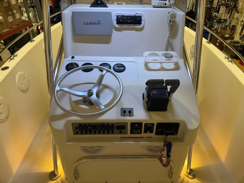 Slide: The Image of 2004 Pursuit 2470 CC boat console with Garmin navigation and steering wheel. - 27