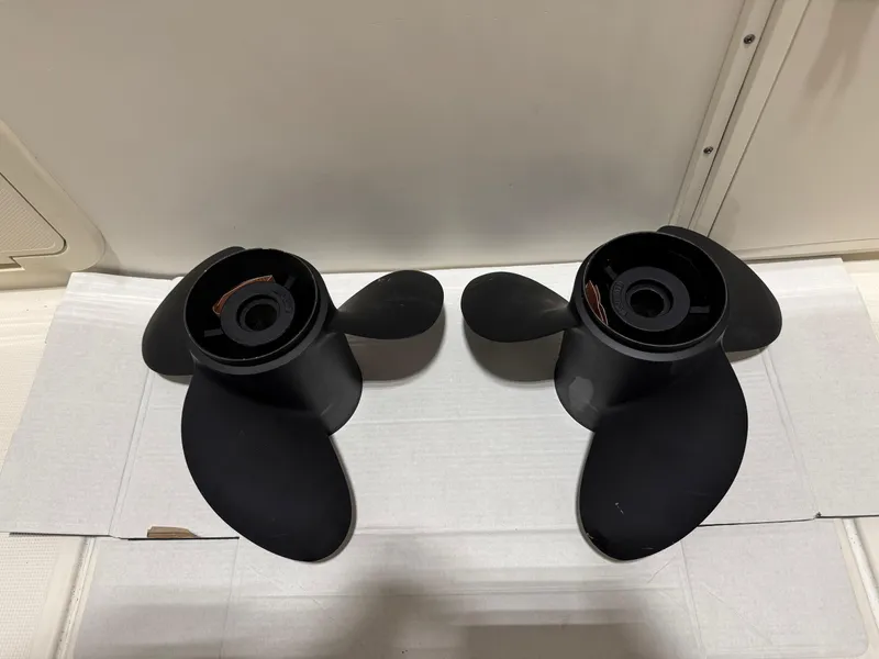 Slide: The Image of Two black boat propellers on a white surface, compatible with 2004 Pursuit 2470 CC. - 29