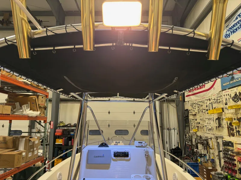 Slide: The Image of 2004 Pursuit 2470 CC boat interior with T-top and equipment in a workshop setting. - 31