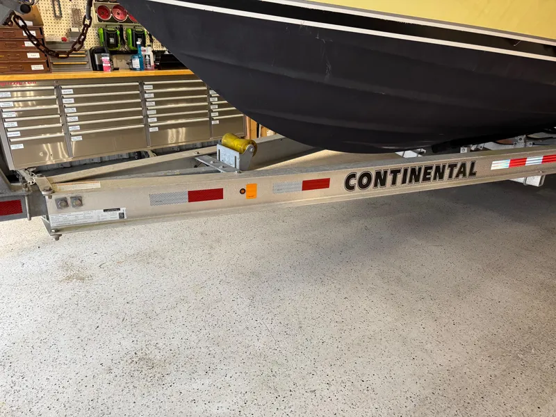 Slide: The Image of Trailer with 2004 Pursuit 2470 CC boat in garage, featuring Continental branding. - 36