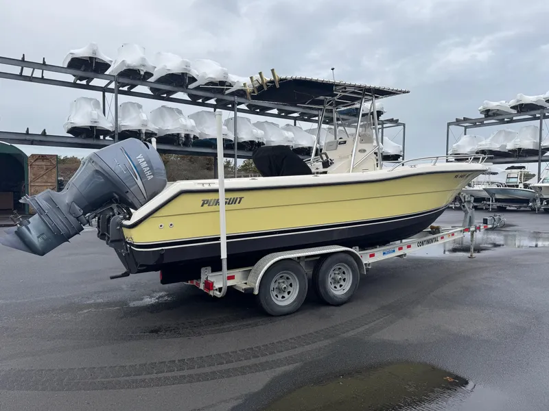 Slide: The Image of 2004 Pursuit 2470 CC boat on trailer, parked in marina storage area. - 4
