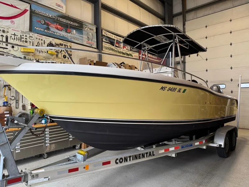 Slide: The Image of 2004 Pursuit 2470 CC boat on Continental trailer in a garage setting. - 5