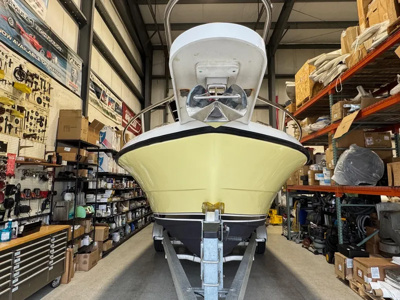 Slide: The Image of 2004 Pursuit 2470 CC boat in storage, surrounded by marine equipment and supplies. - 9