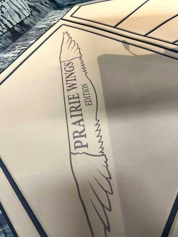 Slide: The Image of 2025 Tracker Grizzly® 1650 T Prairie Wings Edition logo with wing design. - 8