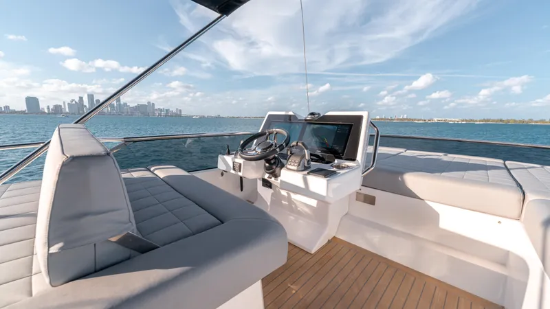 Slide: The Image of 2024 Pardo Yachts E60 helm with city skyline, luxurious seating, and modern navigation equipment. - 19