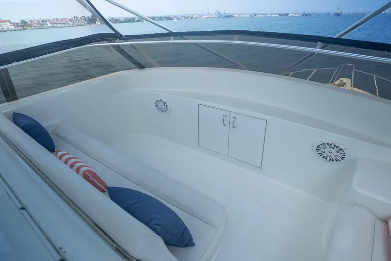 Slide: The Image of 1990 Hatteras 58 Convertible yacht interior with seating and cushions, overlooking the water. - 11