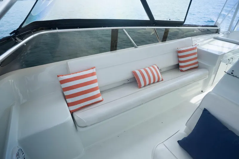 Slide: The Image of 1990 Hatteras 58 Convertible yacht interior with striped cushions on white seating. - 12