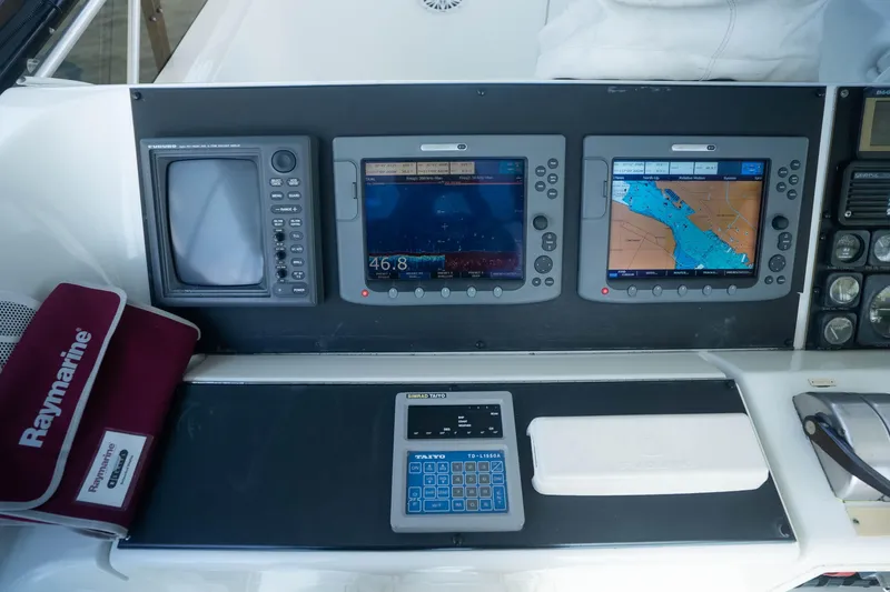 Slide: The Image of Control panel of a 1990 Hatteras 58 Convertible with navigation screens and Raymarine equipment. - 16