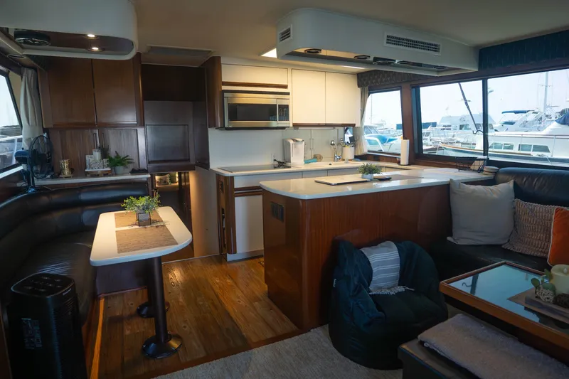 Slide: The Image of Luxurious interior of a 1990 Hatteras 58 Convertible yacht with modern kitchen and seating area. - 19