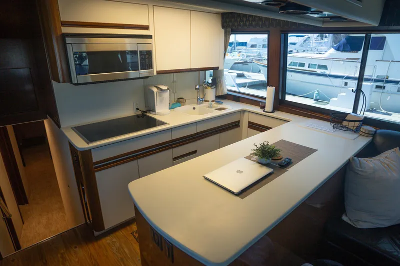 Slide: The Image of Modern kitchen interior on a 1990 Hatteras 58 Convertible yacht with large windows. - 20