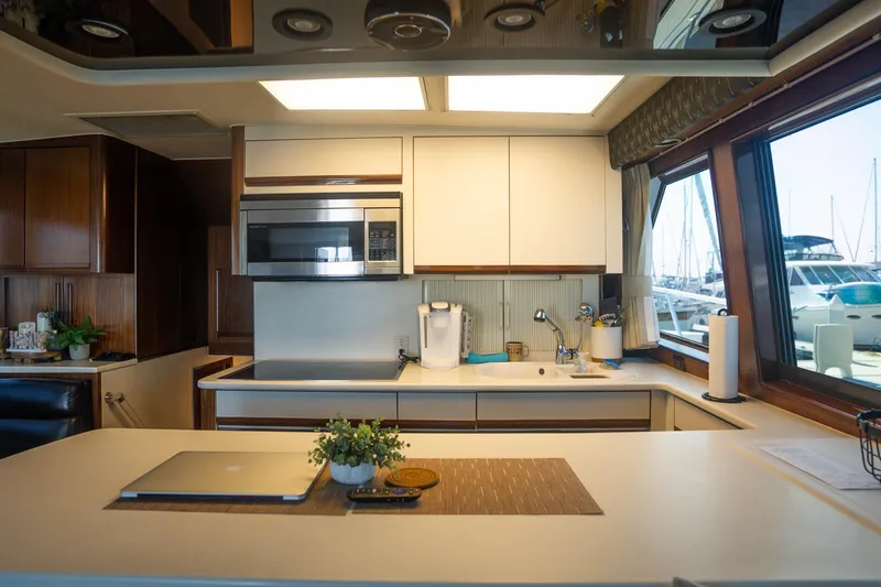 Slide: The Image of Modern kitchen interior on a 1990 Hatteras 58 Convertible yacht with marina view. - 21