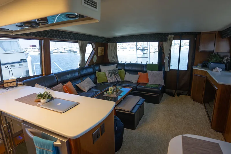 Slide: The Image of Luxurious interior of 1990 Hatteras 58 Convertible yacht with spacious seating and marina view. - 24