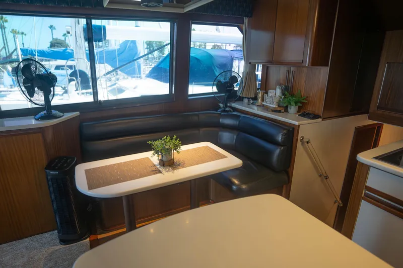 Slide: The Image of Interior of 1990 Hatteras 58 Convertible yacht with cozy seating and dining area. - 25