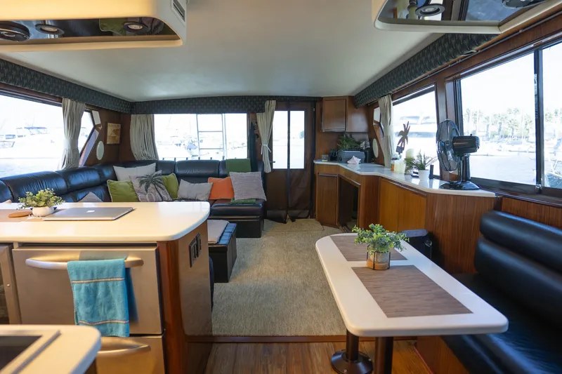 Slide: The Image of Luxurious interior of a 1990 Hatteras 58 Convertible yacht with modern furnishings and large windows. - 26