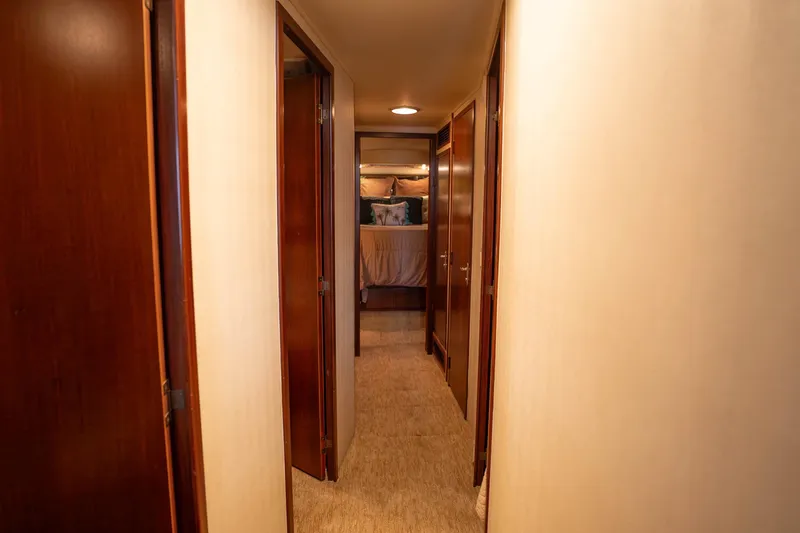 Slide: The Image of Hallway inside 1990 Hatteras 58 Convertible yacht, leading to a cozy bedroom. - 27