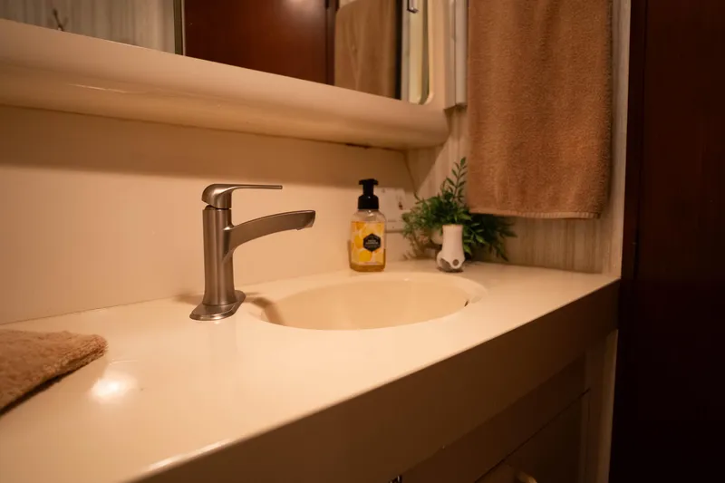 Slide: The Image of Bathroom sink area on 1990 Hatteras 58 Convertible yacht, featuring modern faucet and decor. - 32