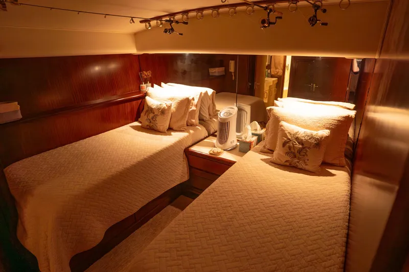 Slide: The Image of Cozy twin bedroom in 1990 Hatteras 58 Convertible yacht with warm lighting. - 37