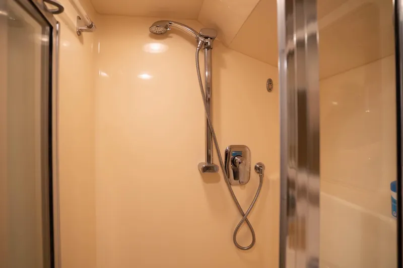 Slide: The Image of Shower area in 1990 Hatteras 58 Convertible yacht, featuring chrome fixtures and beige walls. - 41