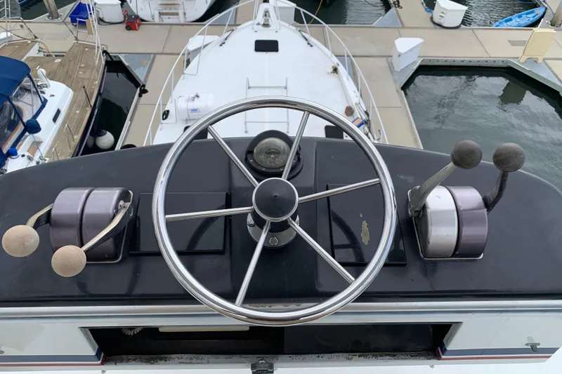 Slide: The Image of Helm of 1990 Hatteras 58 Convertible yacht with steering wheel and controls. - 43