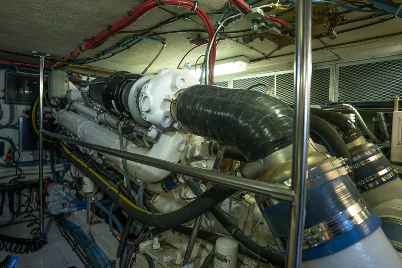 Slide: The Image of Engine room of 1990 Hatteras 58 Convertible yacht, showcasing complex machinery and wiring. - 45