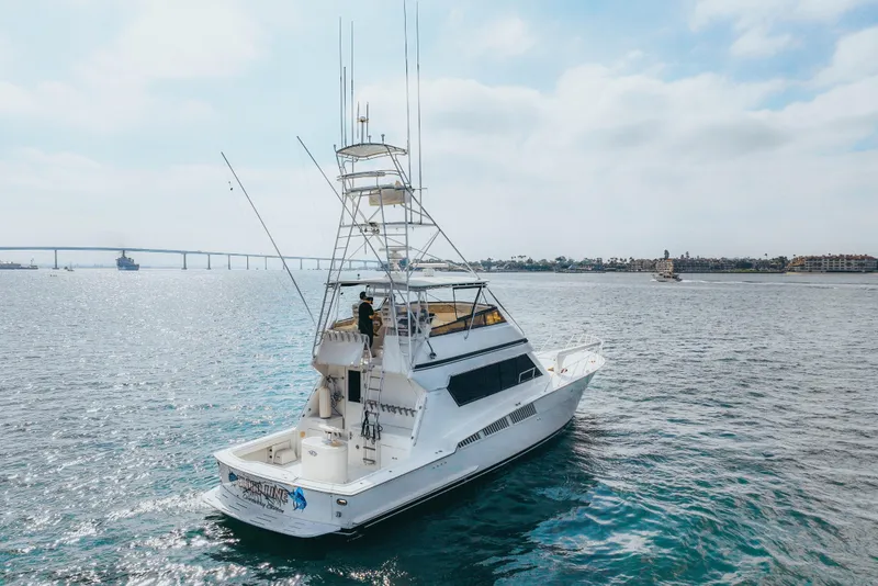 Slide: The Image of 1990 Hatteras 58 Convertible yacht cruising on open water under a clear sky. - 5