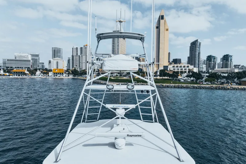 Slide: The Image of 1990 Hatteras 58 Convertible yacht with city skyline in the background. - 7