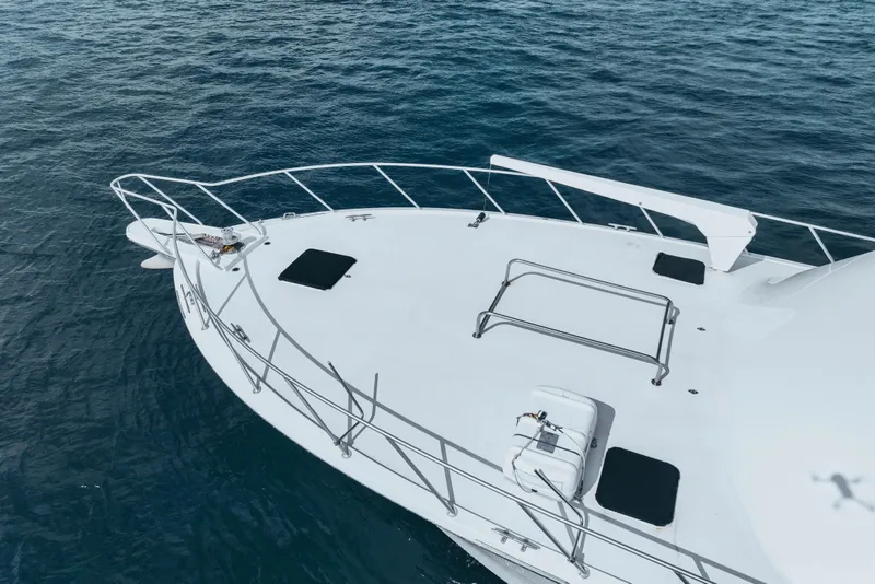Slide: The Image of Bow of 1990 Hatteras 58 Convertible yacht on calm blue water. - 8