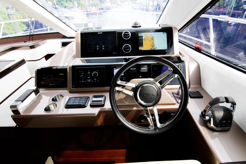 Slide: The Image of Helm of 2020 Galeon 550 Fly yacht with modern navigation controls and steering wheel. - 16