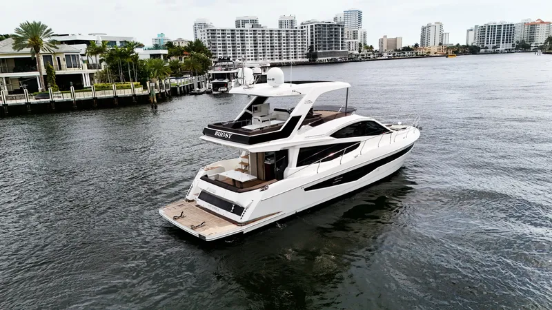 Slide: The Image of 2020 Galeon 550 Fly yacht cruising in a city waterfront setting. - 2