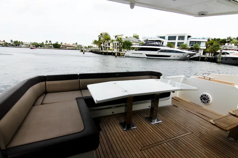 Slide: The Image of Luxury Galeon 550 Fly yacht deck with seating and table, 2020 model, docked by waterfront homes. - 40