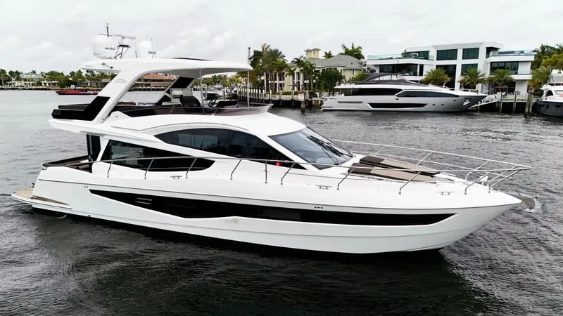 Slide: The Image of 2020 Galeon 550 Fly yacht on water, showcasing sleek design and modern architecture. - 5