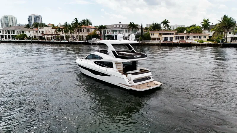 Slide: The Image of 2020 Galeon 550 Fly yacht cruising near waterfront homes. - 6